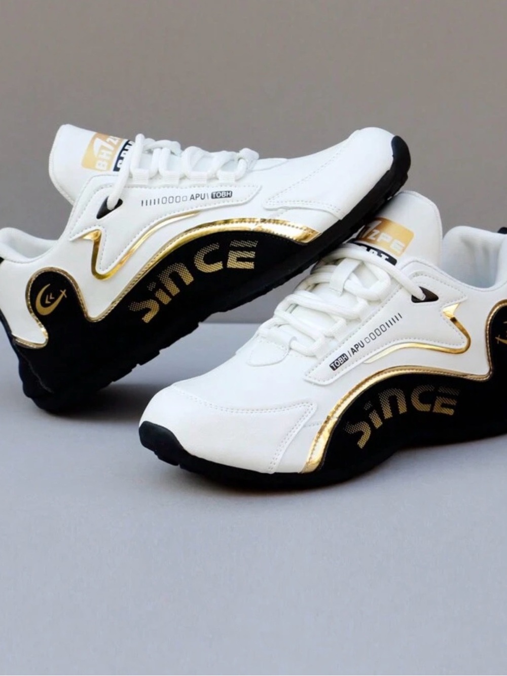 White and Black Athletic Sneakers with Gold Accents - Women